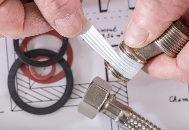 46185046 - plumber putting a teflon joint on a thread, closeup